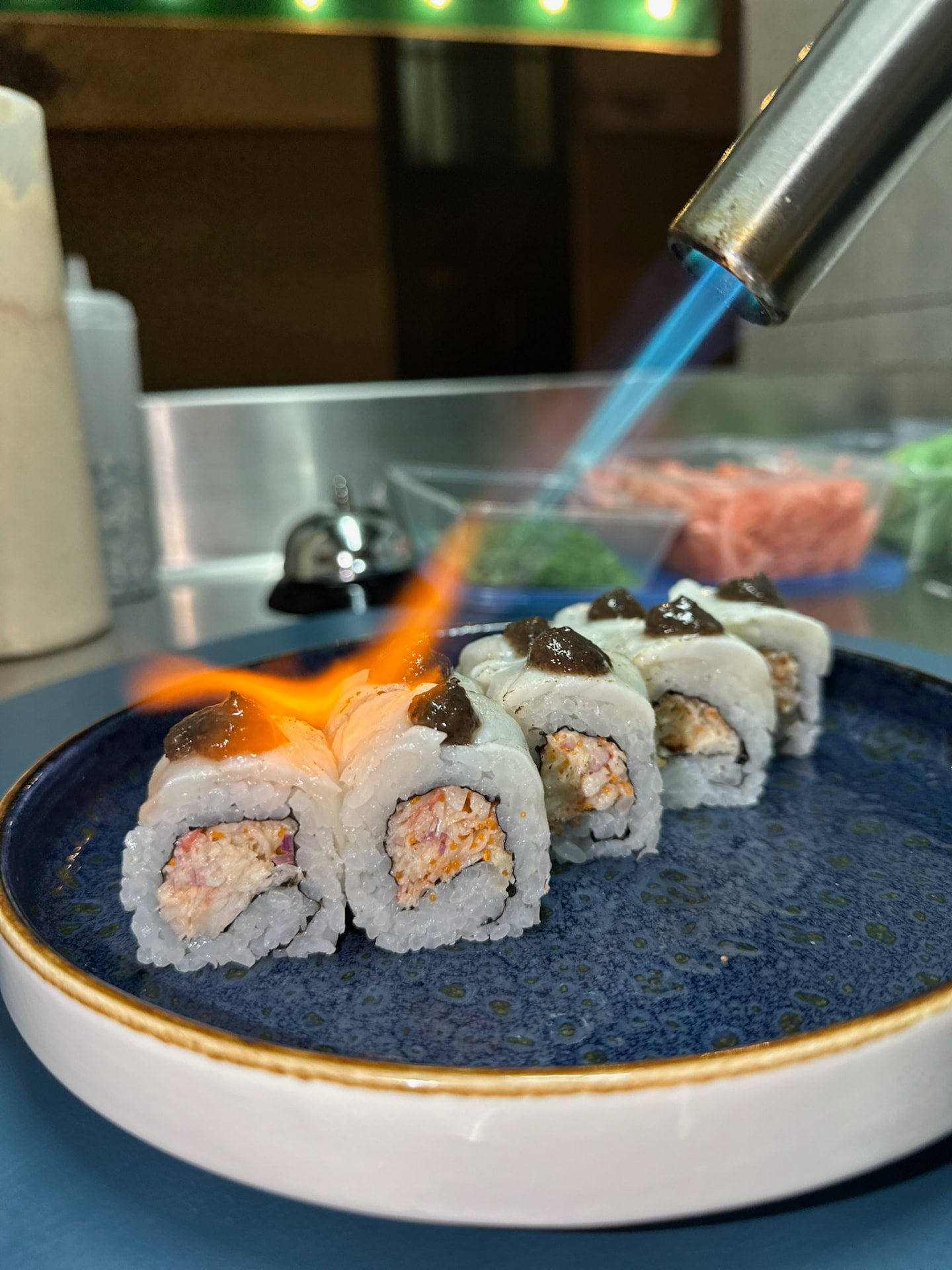 Pieza de sushi de autor flambeada con soplete durante un showcooking en directo